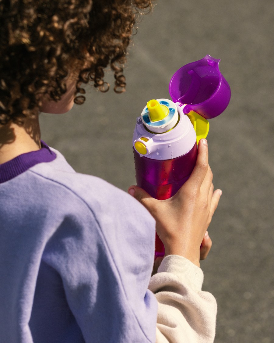 Kid drinking from an air up Click bottle outdoors